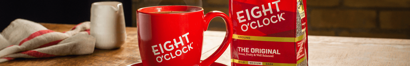 Eight O'clock coffee in a coffee mugs with a bag of coffee bean, creamer at the back.