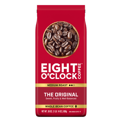 Red Eight O'Clock Coffee bag with coffee beans on a white background